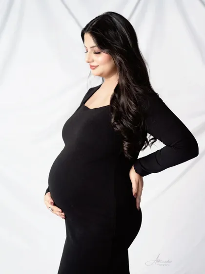 A beautiful and serene solo portrait. The mom-to-be's gentle expression and the classic pose create a timeless image.