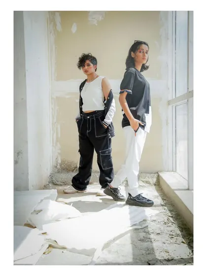 A different composition from the "No Label" shoot, using natural light from a window to create dramatic shadows. The models' poses convey a quiet confidence and challenge traditional fashion norms.