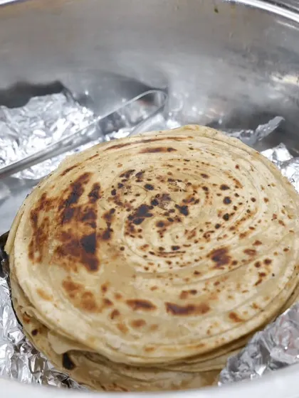 A stack of flaky Malabar Parottas, kept warm and ready to be served.