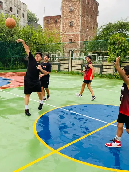A player passes the ball on a wet court, demonstrating careful handling.