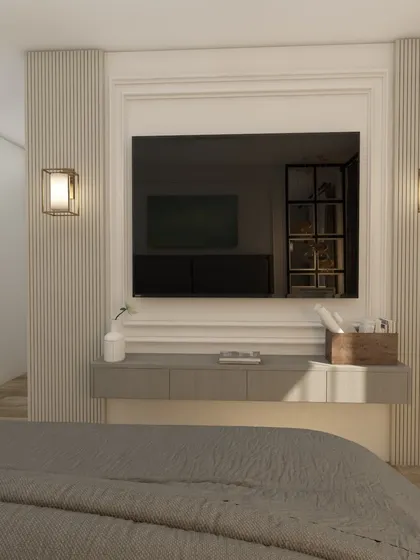 The TV is elegantly framed with molding and flanked by fluted panels and wall sconces, turning the media wall into a beautiful feature.