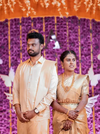 A candid shot of the couple on their wedding stage, capturing their natural expressions.