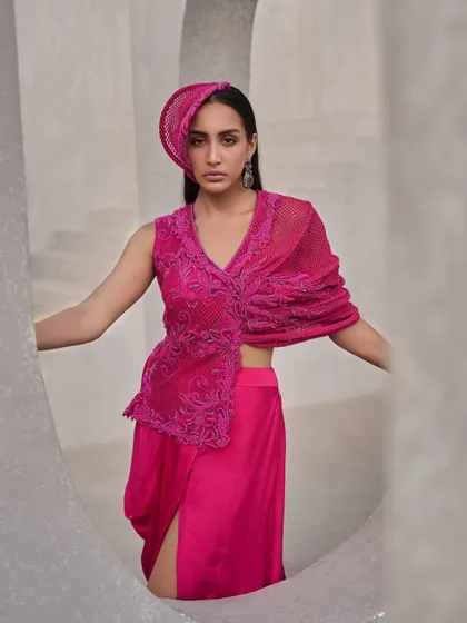 Fluid, fierce, and unapologetically bold. This hot pink two-piece set, with its sheer mesh and fine embroidery, flickers across layers like shifting light.