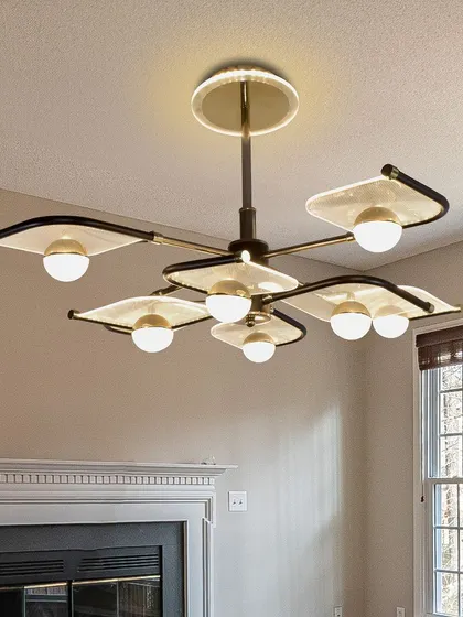 This leaf-panel chandelier looks beautiful over a fireplace, adding a warm and inviting glow to the room.