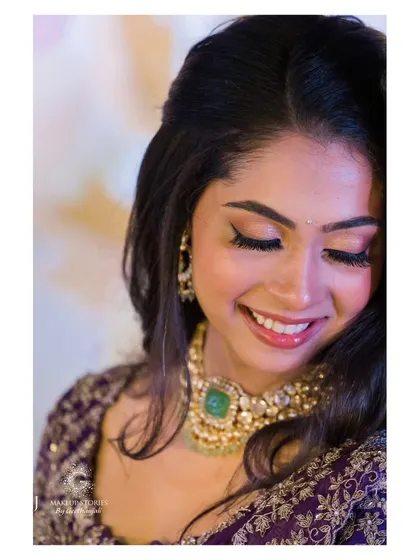 A close up of Vidya's makeup, showing the soft shimmer on her eyelids and her glowing smile. This is a perfect example of a subtle yet glamorous reception look.