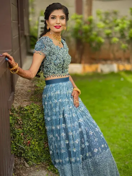 A portrait from the ring ceremony. The makeup features a bright, bold lip that adds a pop of color to the elegant blue lehenga, creating a look that is both fun and sophisticated.