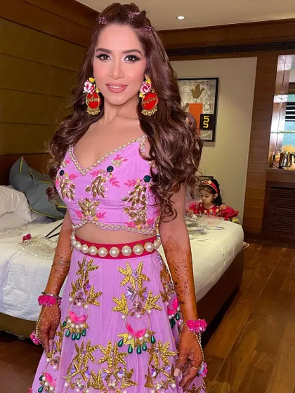 A portrait of the bride, looking radiant with her soft curls and colorful Mehendi attire.
