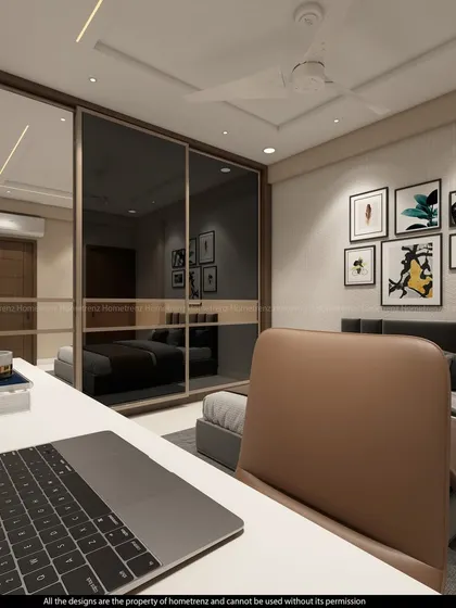 A view from the desk in a guest bedroom, showing the mirrored wardrobe and a gallery wall of art, which adds a personal touch.