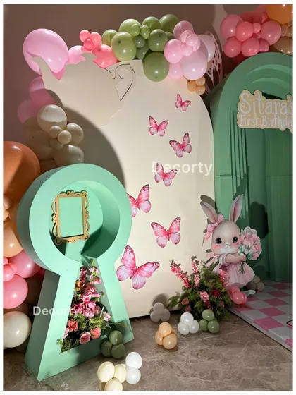 A creative keyhole-shaped prop filled with flowers, adding a unique touch to the whimsical party decor.