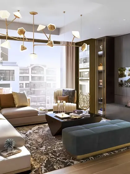 A sunlit living room with large windows, designed with a modern aesthetic. The unique geometric chandelier and a mix of textures in the rug and furnishings add character and warmth to the space.