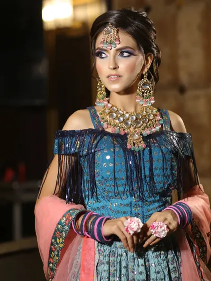 A close-up on the fringed blouse and the heavy jewelry, showing how to style this outfit for a bold and beautiful look.
