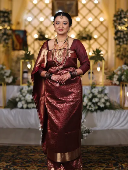 A full-length shot of the bride in her beautiful maroon Kodavathi saree. The makeup is polished, creating a regal and sophisticated look.