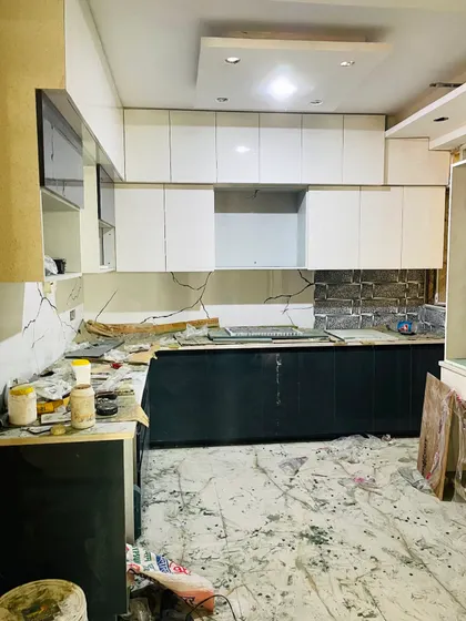 The kitchen in the middle of construction, with the base and overhead cabinets installed but awaiting shutters and final finishing.