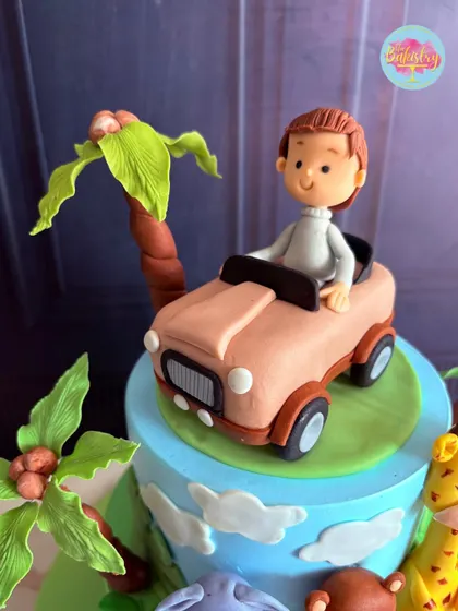 A close-up of the personalized topper for Parikshit's jungle safari cake, featuring a custom figurine of the birthday boy driving his own jeep.