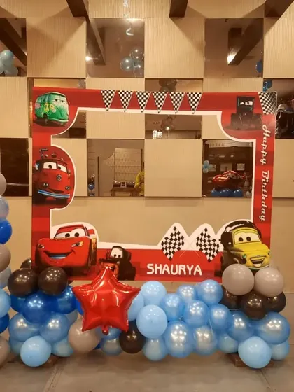 A Disney "Cars" themed photo booth frame. This setup is perfect for taking memorable pictures, with characters like Lightning McQueen and Mater.