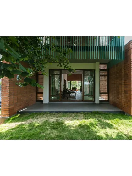 A close-up of the facade of 'An Earthy Affair', where a green pergola provides shade for a ground-floor seating area. This detail illustrates our approach of integrating functional landscape elements directly into the architecture of the home.