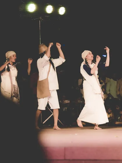 Three dancers on stage, their movements synchronized under the stage lights. This shot shows my ability to capture group performances while maintaining focus on individual expressions.