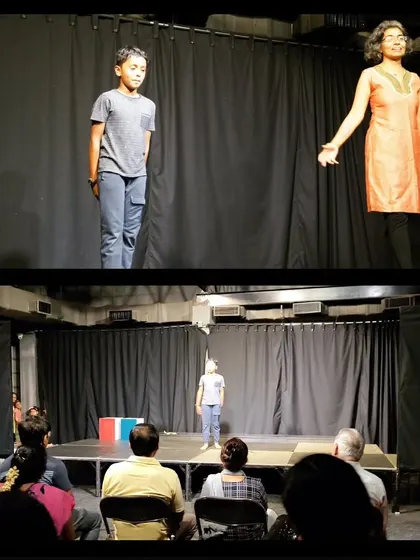 A teacher guides a young student through a monologue during a performance, showcasing the supportive learning environment at Vyoma.