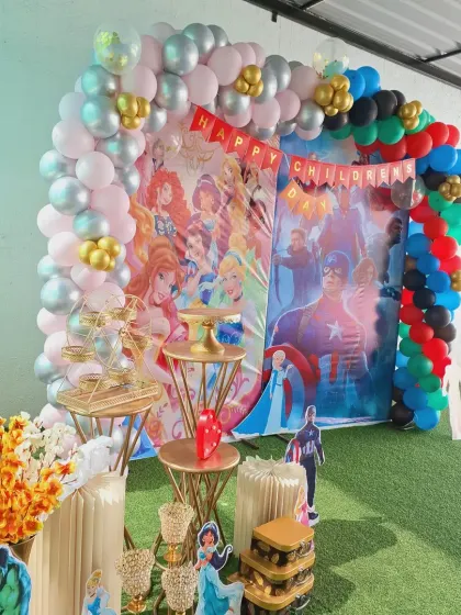 A closer look at the prop table for the Princess and Avengers party, with character cutouts and themed cake stands.