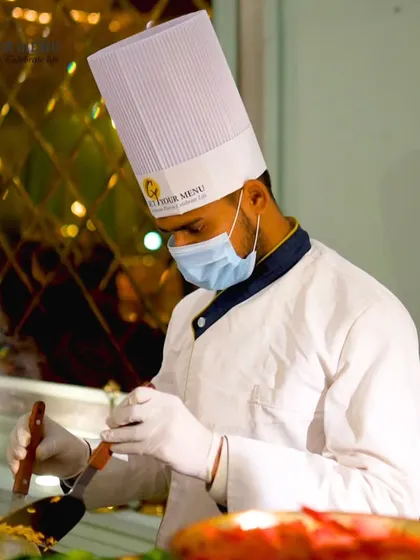 A chef meticulously preparing a dish at a live station. Our team is trained to maintain the highest standards of hygiene and professionalism, even in a busy event setting.