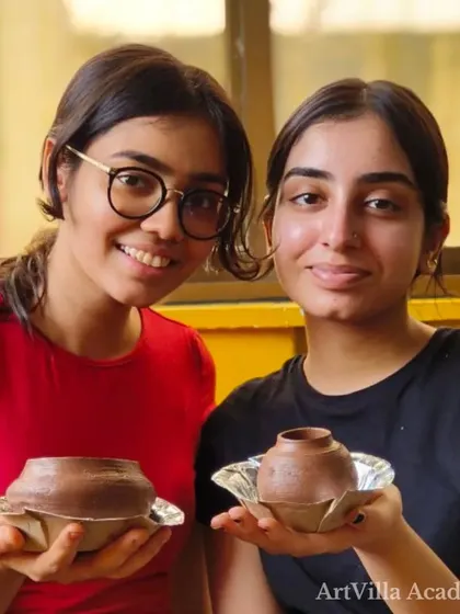 Two friends proudly display the small pots they made during a workshop. It's a perfect activity to share, where you can learn a new skill and create lasting memories together.