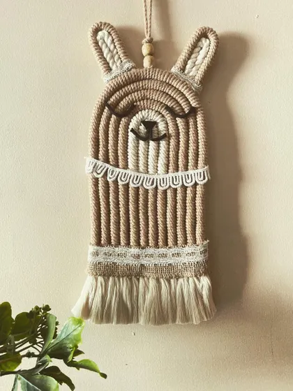 No drama with this llama! This adorable macrame llama wall hanging has a sweet, sleepy expression and is decorated with delicate lace-like details.