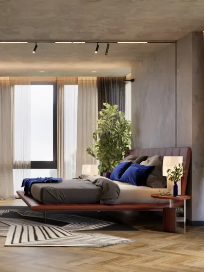This master bedroom in a 3,800 sq ft Kolkata home is designed as an urban retreat. A leather-upholstered bed is accented with deep blue pillows, set against a concrete-finish wall for a modern, industrial touch.