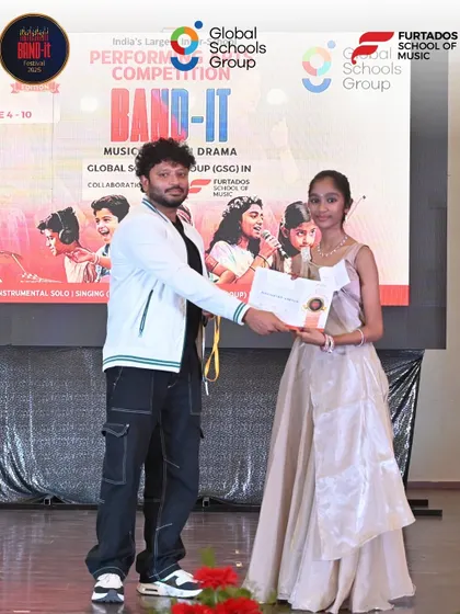 A moment of recognition. A young performer receives her certificate on stage at the Bangalore regional competition.