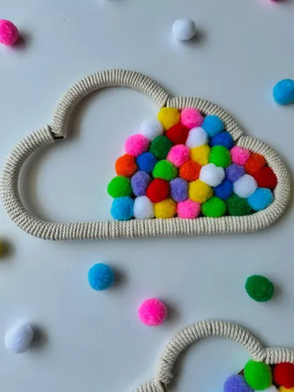 The texture of the wrapped cord frame and the soft pompoms make this cloud hanging a lovely sensory piece for a child's room.