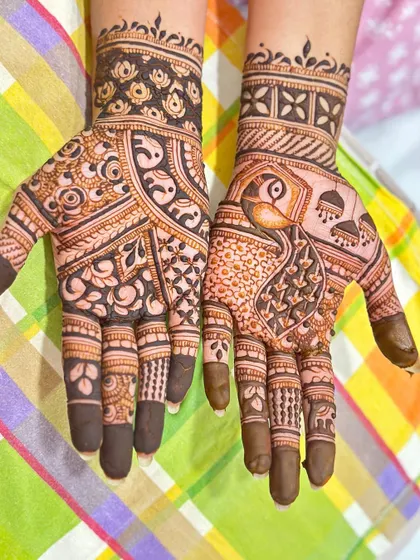 A beautiful designer mehendi with a mix of peacock motifs and floral patterns.