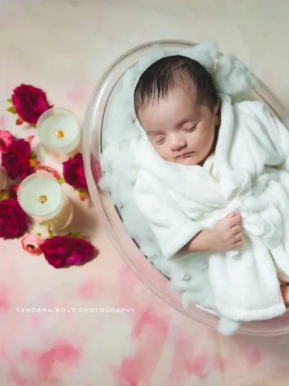 This close-up from the spa-themed newborn session shows the baby peacefully asleep. The focus is on their serene expression and the cozy white robe, making for a sweet and unique portrait.