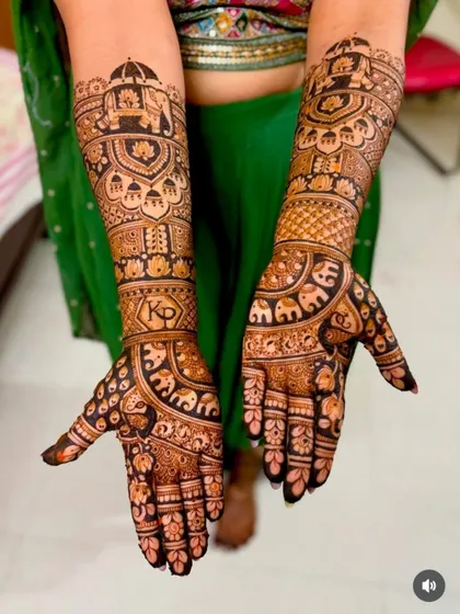 A royal-themed design with elephant processions and the couple's initials 'KD' on the wristband. The palms are filled with tiny, detailed elephants.