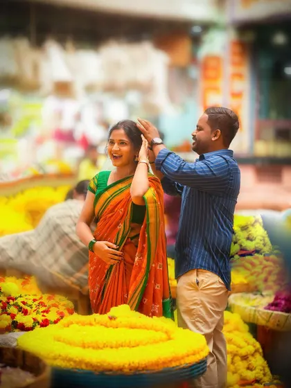 A joyful, candid shot of a couple in a flower market, capturing a genuine moment of laughter.