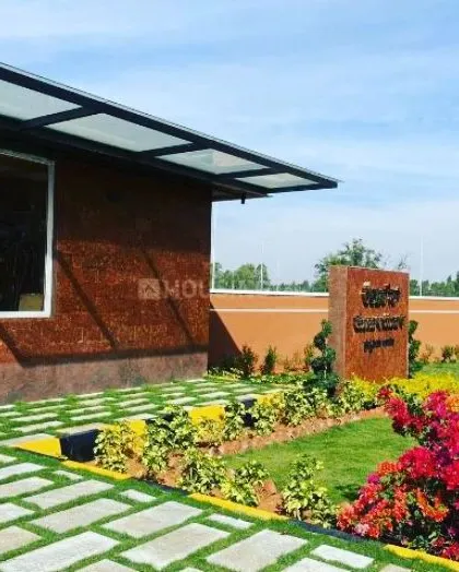 A closer look at the entrance landscaping for the Sarjapura road layout, showing the combination of green lawn, paver stones, and flowering plants that create a welcoming first impression.