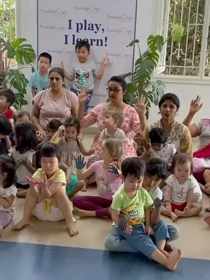A group photo of our students and teachers with colorful hands after a fun Holi art activity.