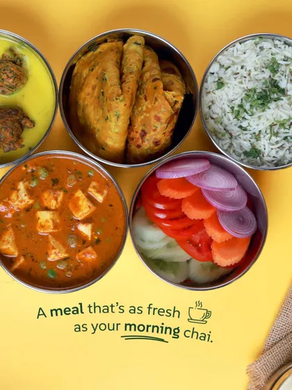 A meal that's as fresh as your morning chai. This spread includes kadhi pakoda, matar paneer, thepla, rice, and salad, showing the delicious variety you can expect.