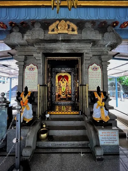 The intricately carved stone entrance to the inner sanctum of a temple, with guards and deities flanking the doorway.