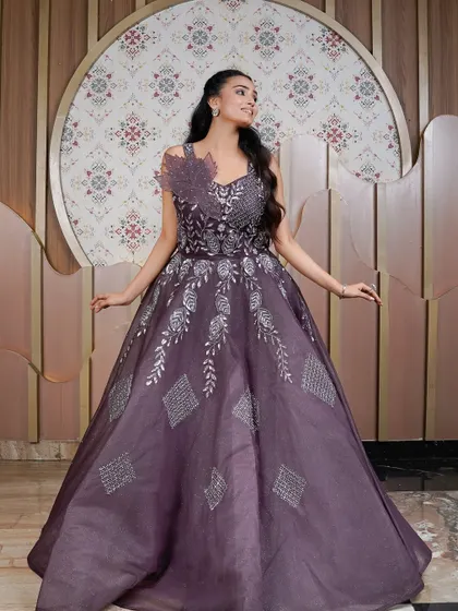 A joyful and radiant full-length shot of the purple gown. This image captures the dress in its entirety, showing off the beautiful A-line silhouette and intricate patterns on the skirt.