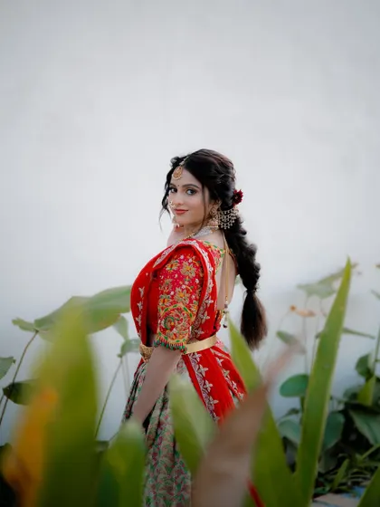 A beautiful over-the-shoulder look. This pose is elegant and timeless, highlighting the bride's profile and the intricate details of her braided hairstyle.