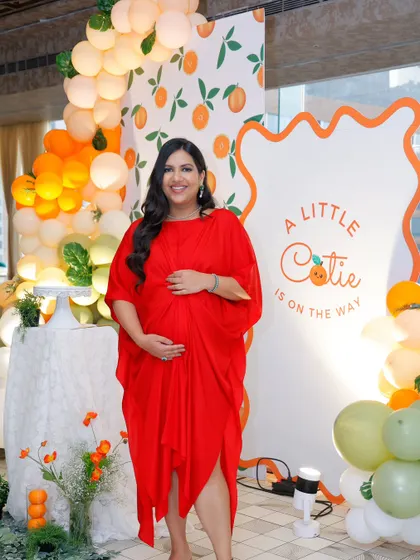 The beautiful mom-to-be glows in front of the citrus-themed backdrop. Her joy is the reason we pour so much love into creating these special moments.