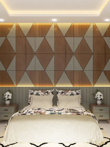 Another bedroom design from the Yelahanka project, showcasing a geometric headboard wall made of wood and fabric panels. The warm, ambient lighting enhances the texture and creates a cozy feel.
