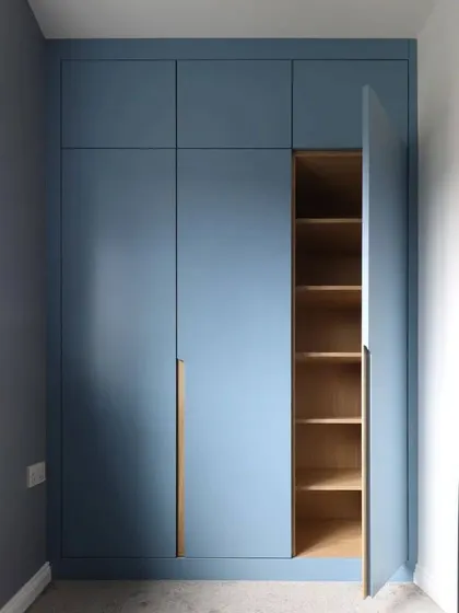 A view of the blue wardrobe with one door open, showing the light wood interior and adjustable shelving.