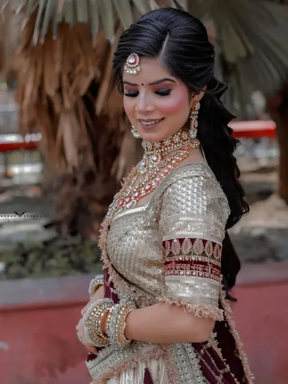 A serene portrait of the bride looking down with a gentle smile. The natural outdoor lighting creates a soft and flattering effect.