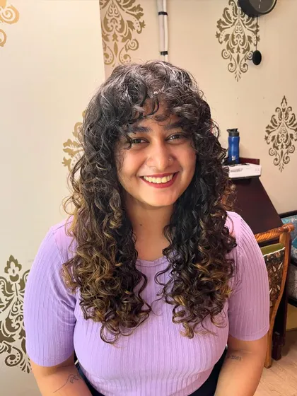 A beautiful curl transformation for Dnyaneshwari, featuring curly bangs and layers to add shape to her long hair.