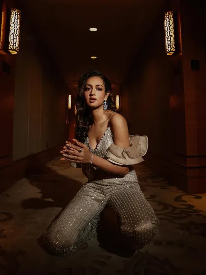 A symmetrical, powerful pose that centers the frame and draws attention to the detailed craftsmanship of the sequined outfit.