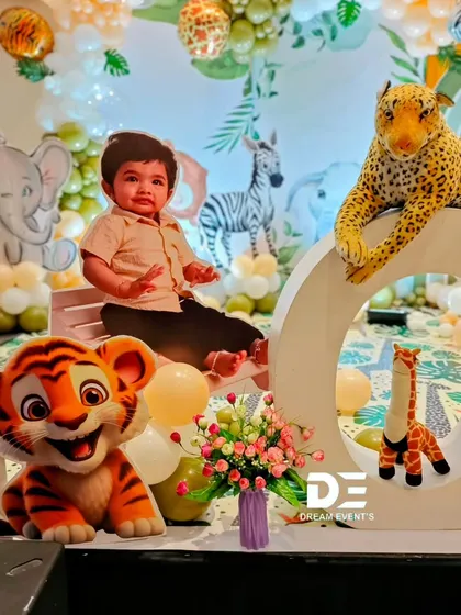 A detail shot from Atharva's party showing a large 'ONE' sign with his photo, surrounded by jungle animal props.