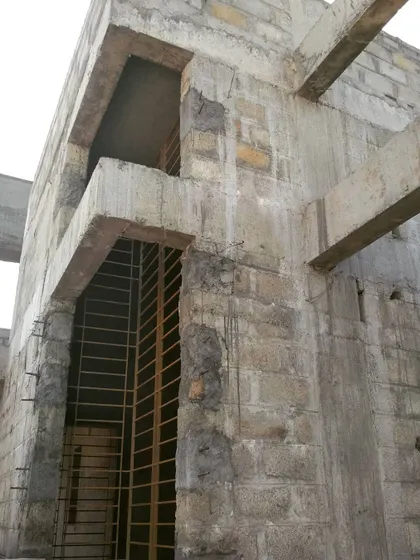 The raw structure of a residential facade before cladding. This shows the concrete and blockwork that forms the canvas for the final architectural finishes.