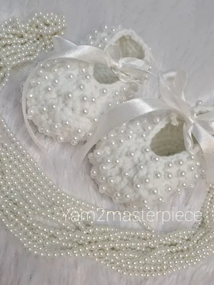 My white pearl booties styled with a string of pearls to emphasize their elegance. The satin ribbon adds a soft, classic finishing touch.