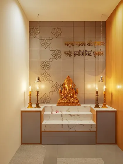 This pooja room design features a golden Ganesha on a marble pedestal. The wall is inscribed with a Sanskrit shloka, creating a deeply sacred and personalized space.