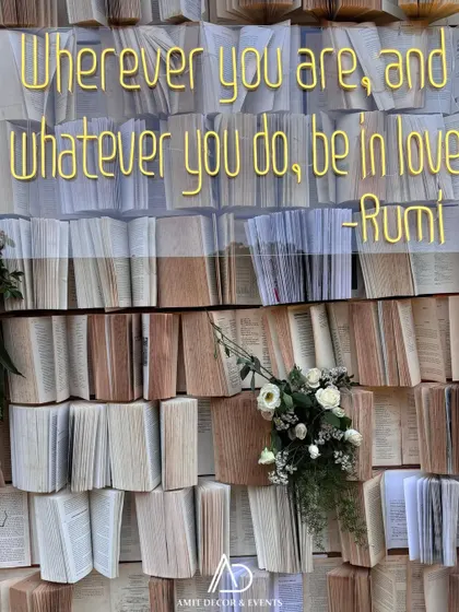 A close-up of the Rumi-inspired book wall, showing the texture of the pages and the elegant gold lettering of the quote.
